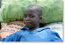 A young boy with vegetable crop in Marracuene.